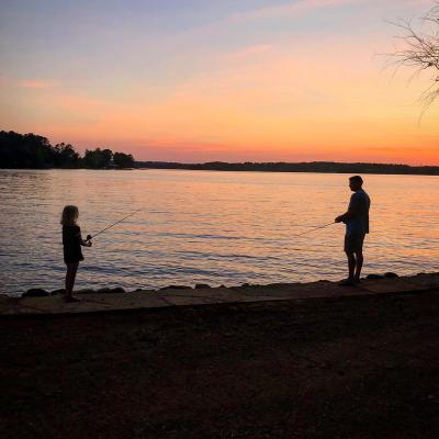 Father and daughter fishing at sunset on Lake Norman