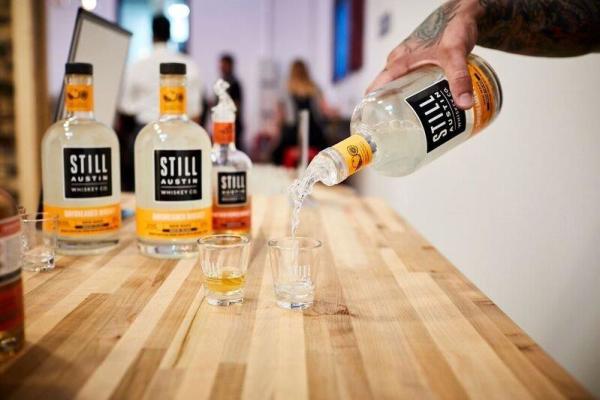 Pouring shot from bottle of Still Austin Whiskey Co