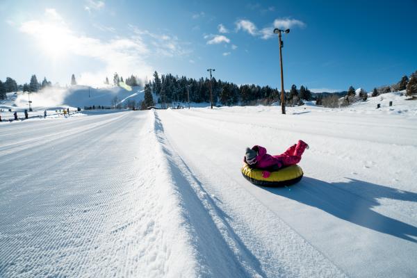 young kid going down a winter tubing track