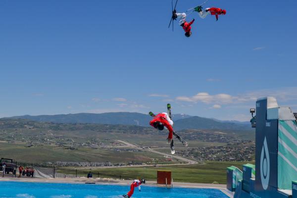 Freestyle Skiers jumping into a pool