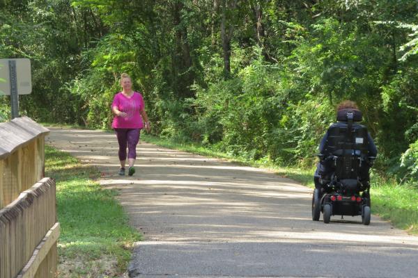A person using a wheelchair on the Tammany Trace trail
