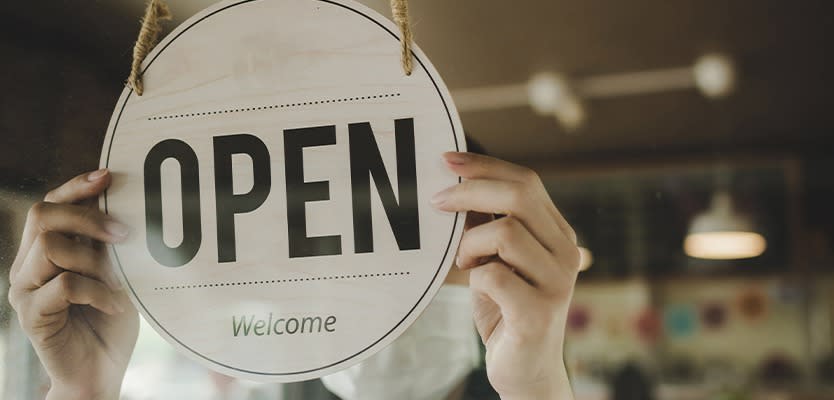 Hands flipping a sign from Closed to Open