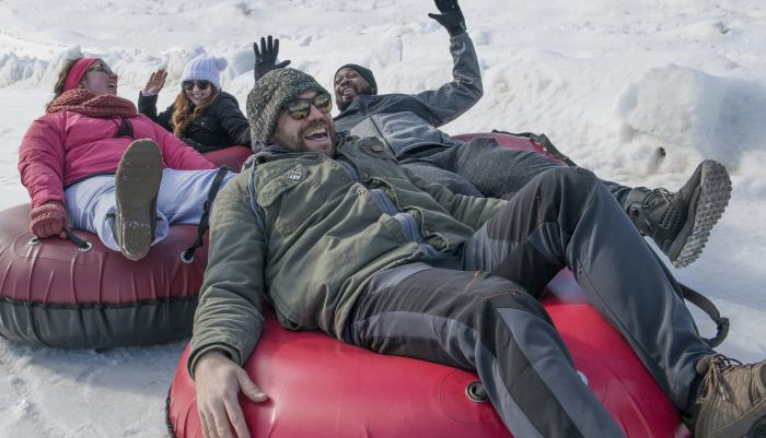 A group of young adults enjoy snow tubing at Roundtop Mountain Resort