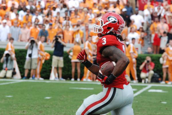 UGA football player running with the ball at a Georgia football game