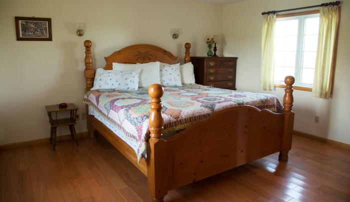 Bed inside of the Cayuga Cottage's king room Bed inside of the Cayuga Cottage's king room