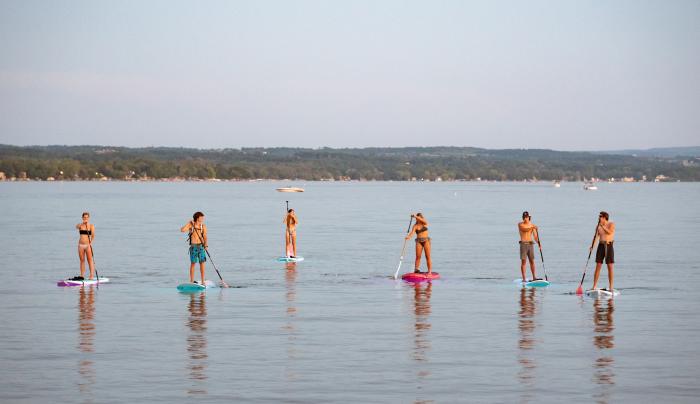 Group of people stand up paddleboarding Group of people stand up paddleboarding