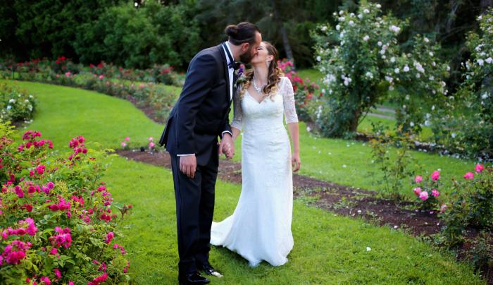 A bride and groom kiss within the gardens at Sonnenberg Mansion A bride and groom kiss within the gardens at Sonnenberg Mansion