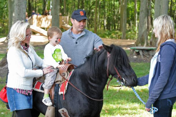 Kid riding horse at Kustermans with family