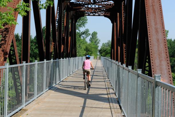 woman cycling on iron bridge