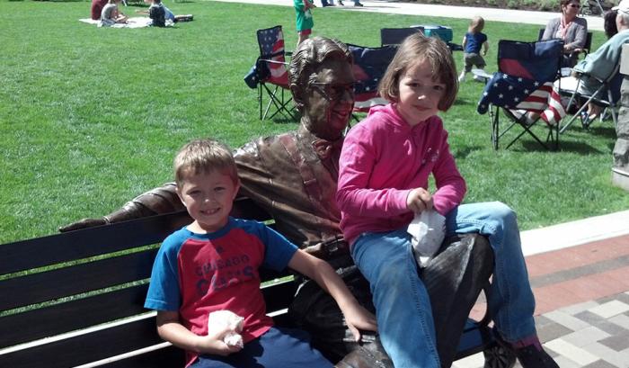 Children Sitting On The Orville Redenbacher Statue