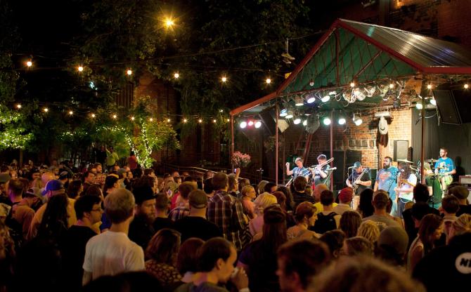 Ophil perform in front of a large crowd at night at Brickyard
