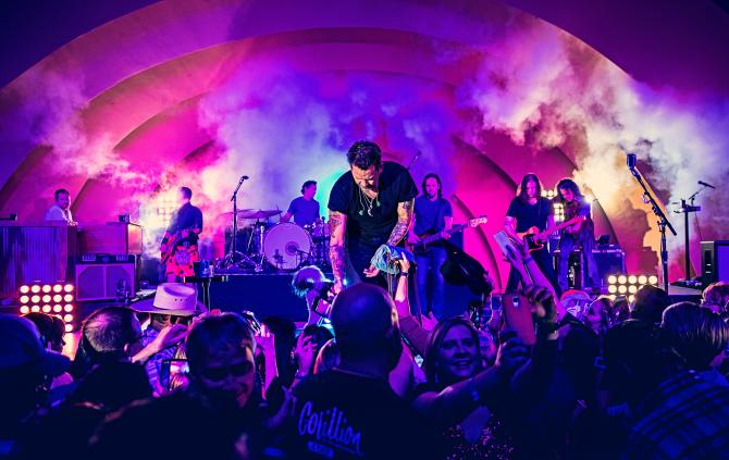 A rock band finishes a set in front of a large crowd at the Cotillion