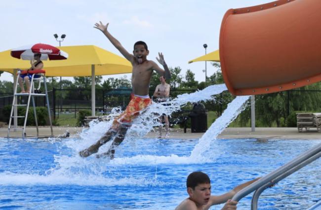 A young boy makes a face at the camera while he shoots out of a water slide at Rock River Rapids