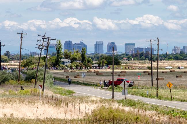 Amgen Tour of California riders in West Sacramento with downtown skyline.