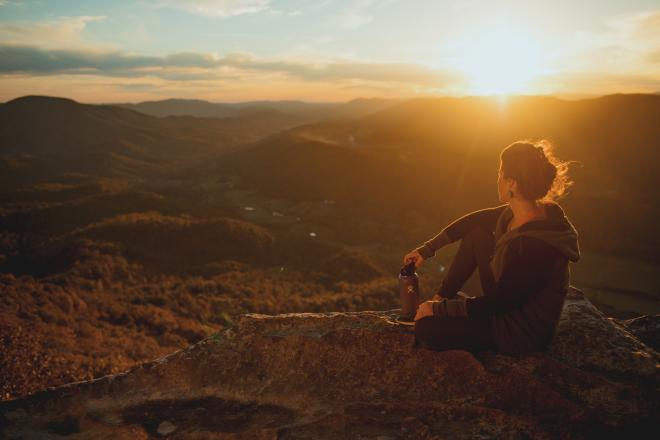 A hiker watching the sunset on the Tinker Cliffs Hiking Trail near Roanoke, Virginia