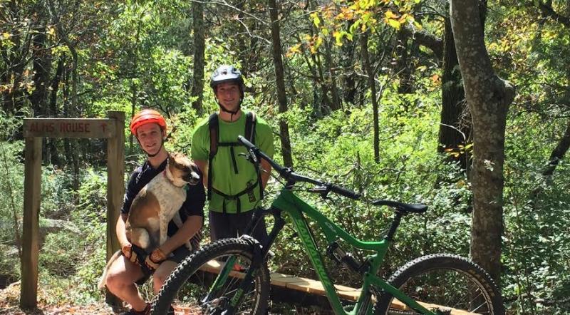 Two mountain bikers and a dog at the Land Trust of North Alabama