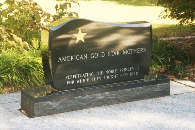 Photo of the front of the American Gold Star Mothers Memorial - a black statue with a gold star and white text reading "American Gold Star Mothers. Perpetuating the noble principles for which they fought and died."