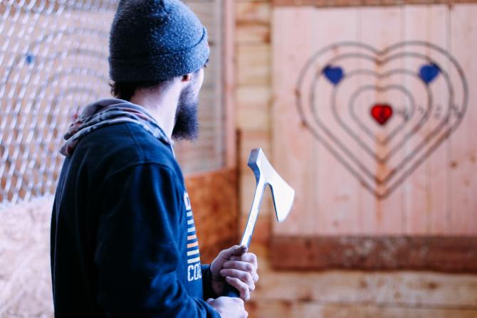 A man prepares to throw an ax at a target at Blade and Timber in Wichita