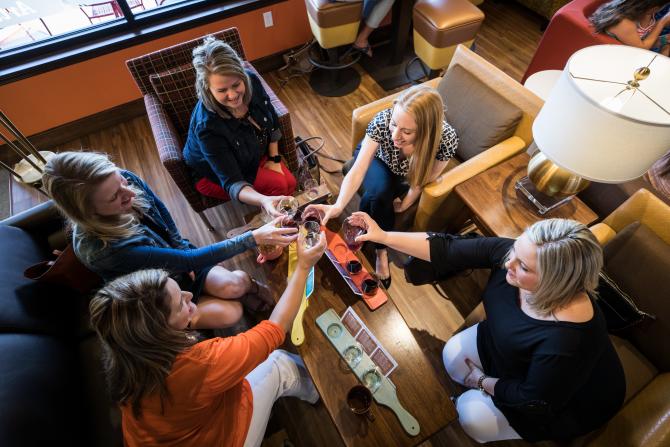 A group of women cheers with wine at Cocoa Dulce in Wichita