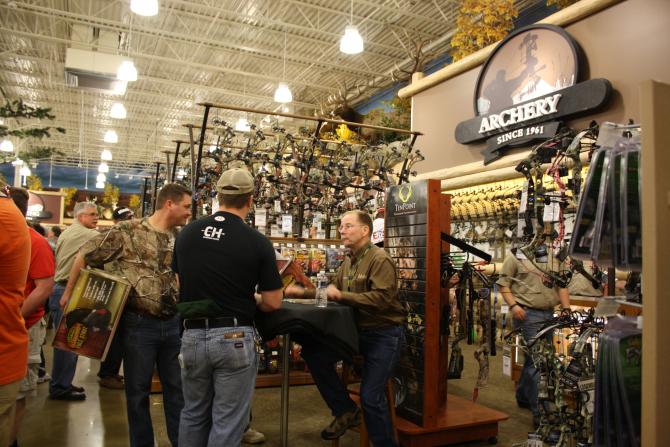 Three men discuss archery equipment at Cabela's in Wichita