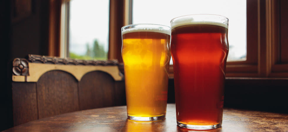 3 Legged Crane Pub and Brewhouse by Todd Cooper A red ale and a lager side by side on a table at the three legged crane pub.