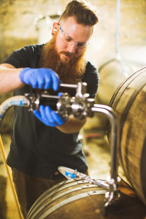 Wolf's Ridge head brewer Chris Davison working with barrels in brewery space