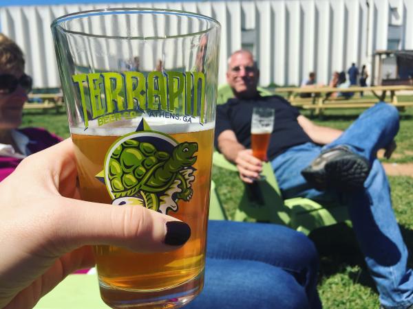 A patron holding up a Terrapin beer glass at Terrapin Brewery in Athens, GA
