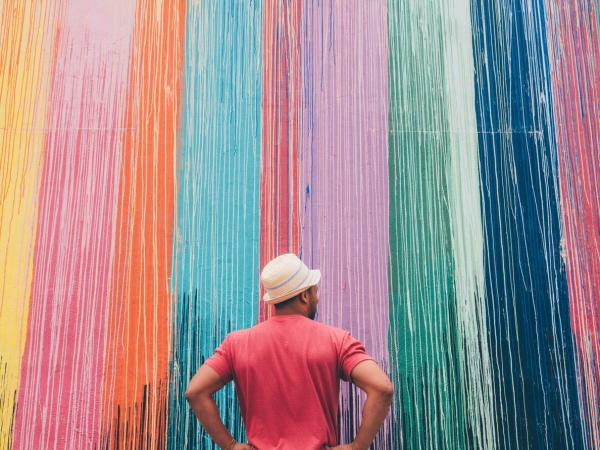 A man stands in front of the Montrose Paint Wall in Houston, TX