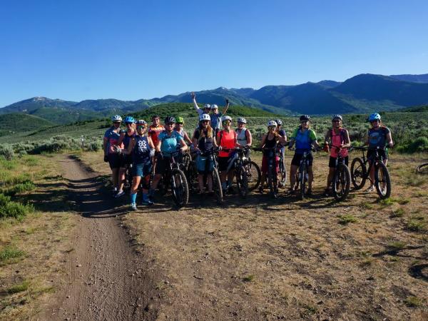 Women with mountain bikes pose for a group photo