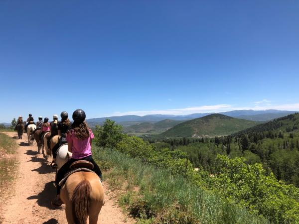 Group of people on horseback with mountain's in background