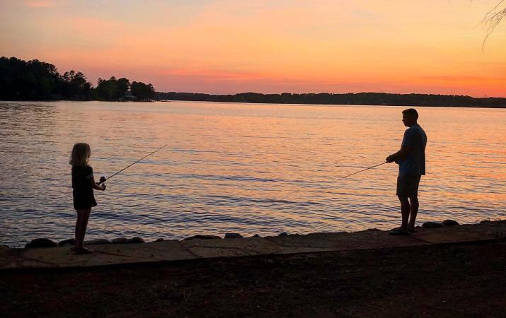 Father and daughter fishing at sunset on Lake Norman