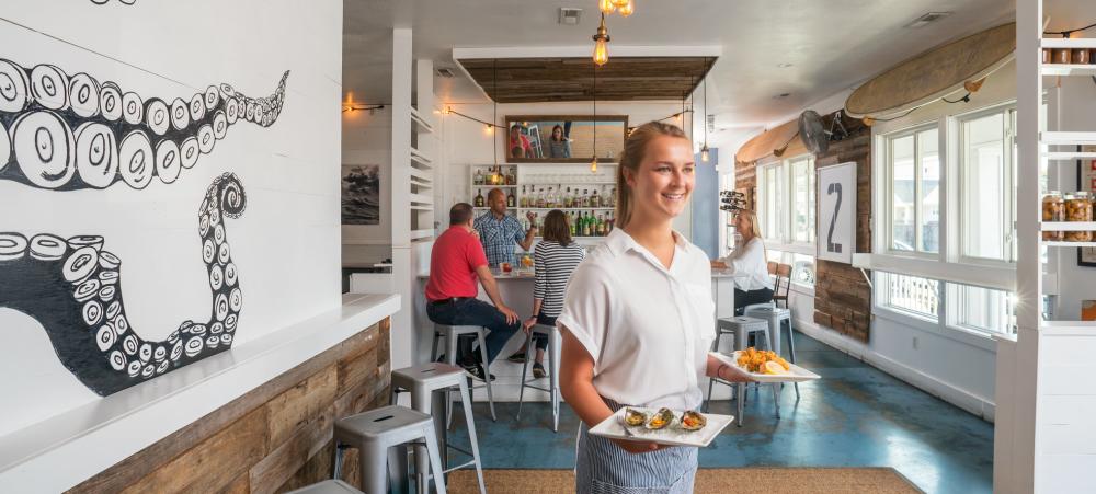 Surf House Oyster Bar & Surf Camp waitress carrying food