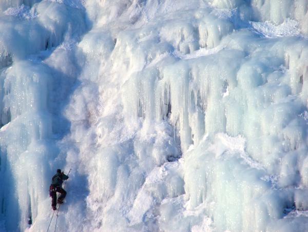 an ice climber on a frozen waterfall