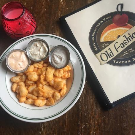A plate of cheese curds with dipping sauces at The Old Fashioned