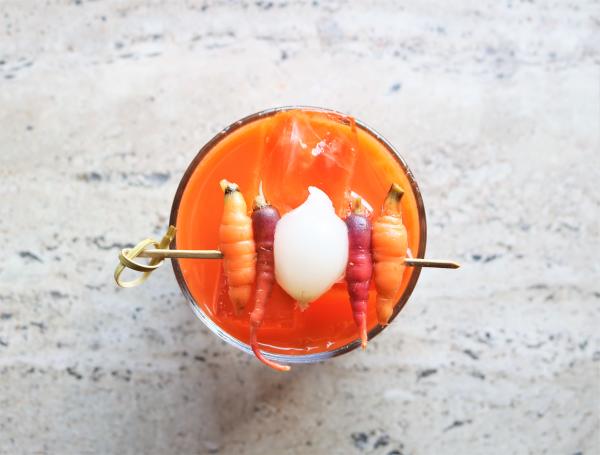 24 Carat Magic cocktail with carrots on a toothpick