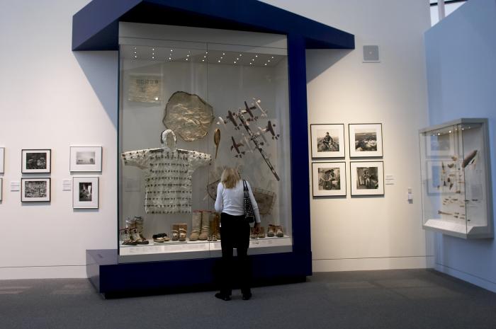 woman viewing Alaska Native artifacts in a museum setting