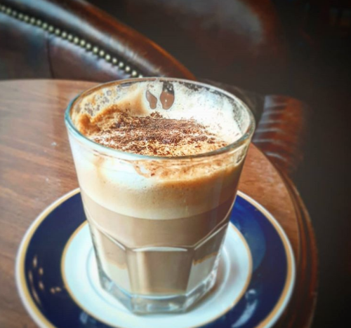 A glass of frothy-topped coffee from Wholly Grounds coffee shop in Dayton.