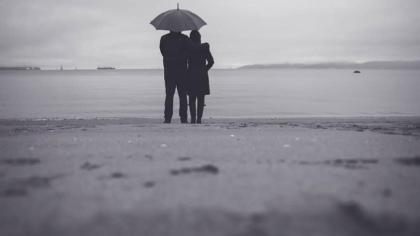 Couple on the beach in the rain