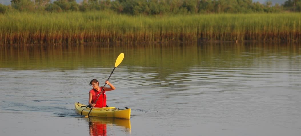 Woman in red vest kayaking in Carolina Beach salt marsh
