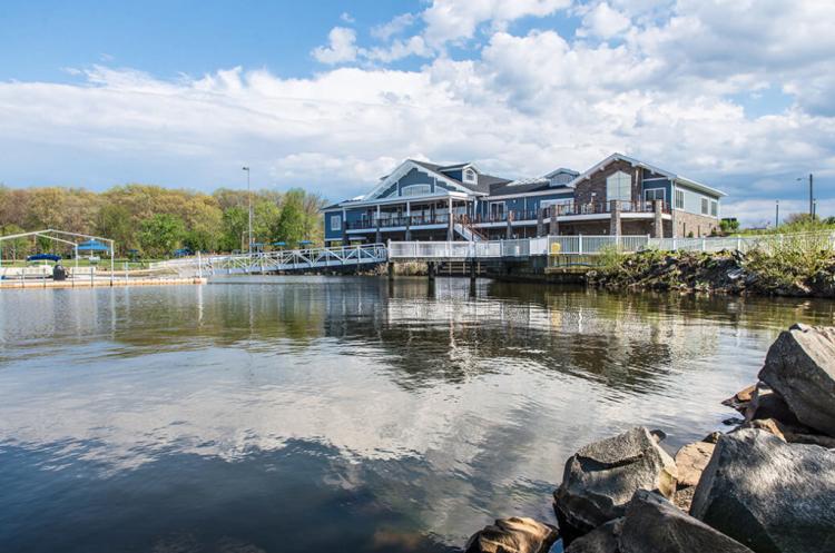 A boathouse sits on Mercer Lake surrounded by grass and rocks