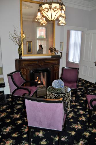 Saratoga Arms sitting room with mauve chairs and fire in fireplace