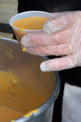 Closeup of a hand holding a cup of Chowder