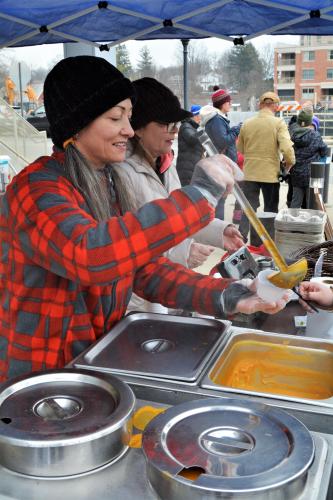 Woman ladeling chowder into bowl for Fitzys