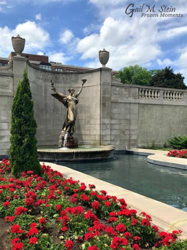 Spirit of Life surrounded by red geraniums in Congress Park