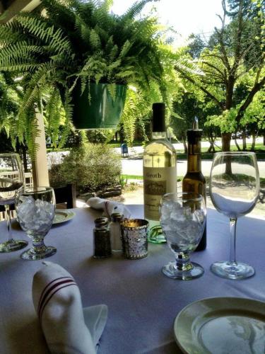 Bottle of wine with empty glasses and plates on patio table at The Brook Tavern