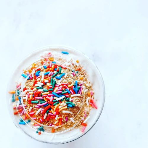 A birthday cake flavored fitness shake is topped with sprinkles.