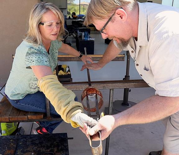 Gregory T. Glass Blowing studio working with a customer