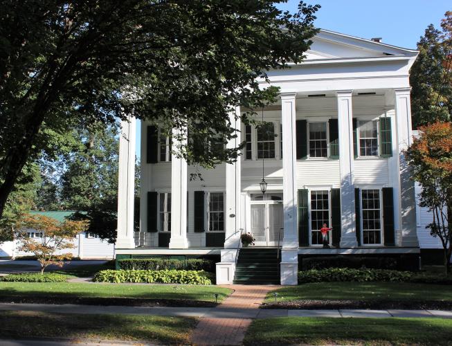 White, two story house with pillars and porch in Saratoga Springs NY