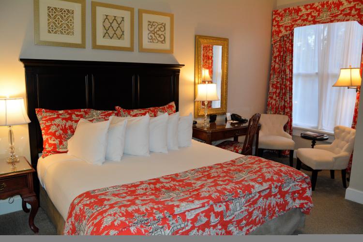 Bedroom with red comforter and white pillows