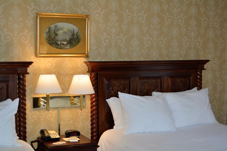 Inn at Saratoga room with twin beds, lamps and framed print